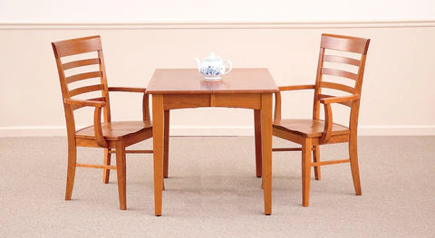 A Scandinavian influenced table with two chairs in a cherry colored wood