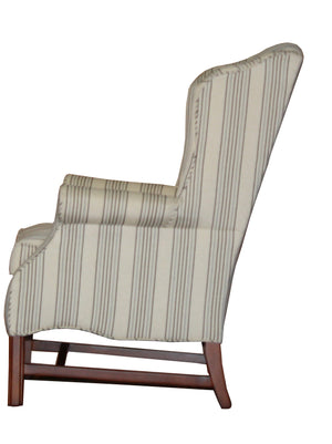 A carmel wingback chair in a light striped fabric, side view